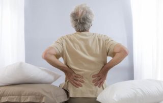 Senior man holding lower back pain treatment active approach to recovery Propel Physiotherapy