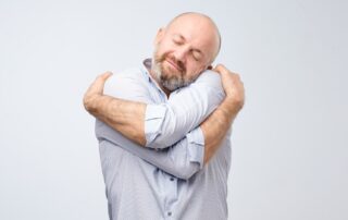 Man hugging himself. 5 healthy ways to show yourself some love on Valentine's Day. Propel Physiotherapy.