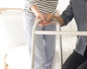 Elderly woman using walker to stand up from edge of bed. Chronic stroke rehabilitation client case study at Propel Physiotherapy.