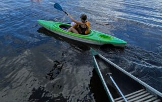 Woman and child kayaking on the lake. Strech and strengthening exercises for paddling from Propel Physiotherapy.