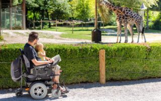 Father in wheelchair with daughter at the zoo. SMA spinal muscular atrophy treatment Propel Physiotherapy.