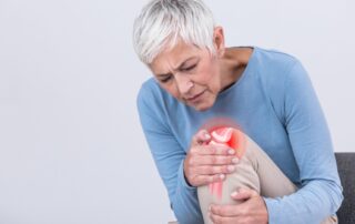 Woman with knee pain. Knee osteoarthritis physiotherapy at Propel Physiotherapy.
