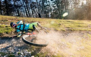 Man falling off of his bike on a trail. How to reduce the risk of concussion in cycling. Propel Physiotherapy concussion prevention and post-concussion rehabilitation program.