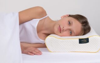 Girl resting on Pillowise orthpedic pillow. Get measured for your personalized pillow at Propel Physiotherapy.