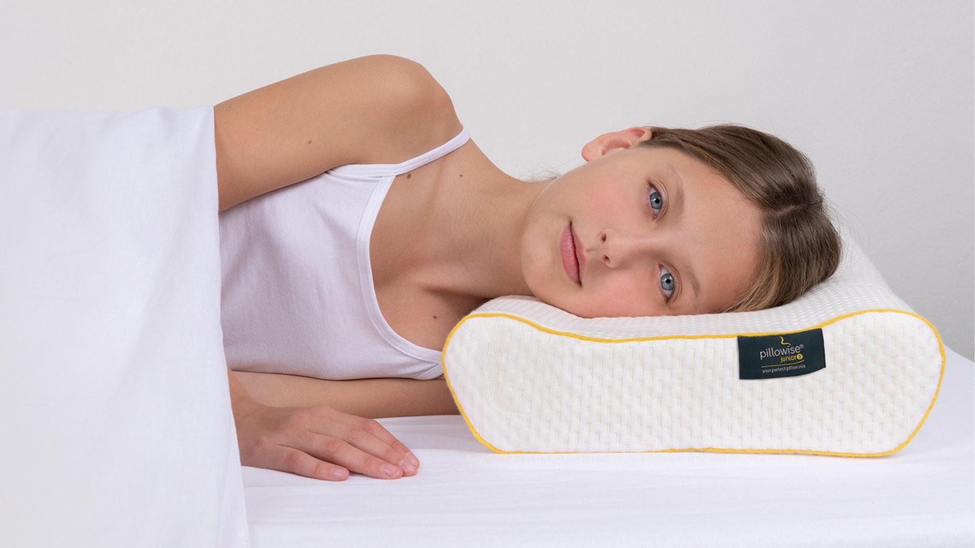 Girl resting on Pillowise orthpedic pillow. Get measured for your personalized pillow at Propel Physiotherapy.