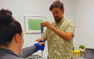 Occupational therapist Gabriel Boutilier doing hand therapy with client. Stroke occupational therapy at Propel Physiotherapy.