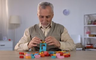 Man playing with blocks in cognitive rehabilitation therapy session with occupational therapist at Propel Physiotherapy.