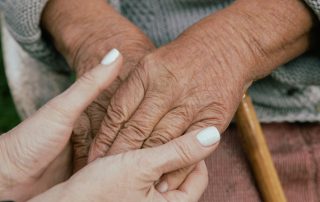 Caregiver holding hands of elderly women with dementia. Alzheimer's disease tools and resources for caregivers. Propel Physiotherapy provides education on assistive devices and transfers, as well as physical therapy, massage therapy and mindfulness training to support caregivers.