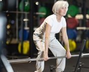 Older woman doing a deadlift exercise at the gym. How resistance training reduces risk of osteoporosis fractures. Propel Physiotherapy healthy aging.