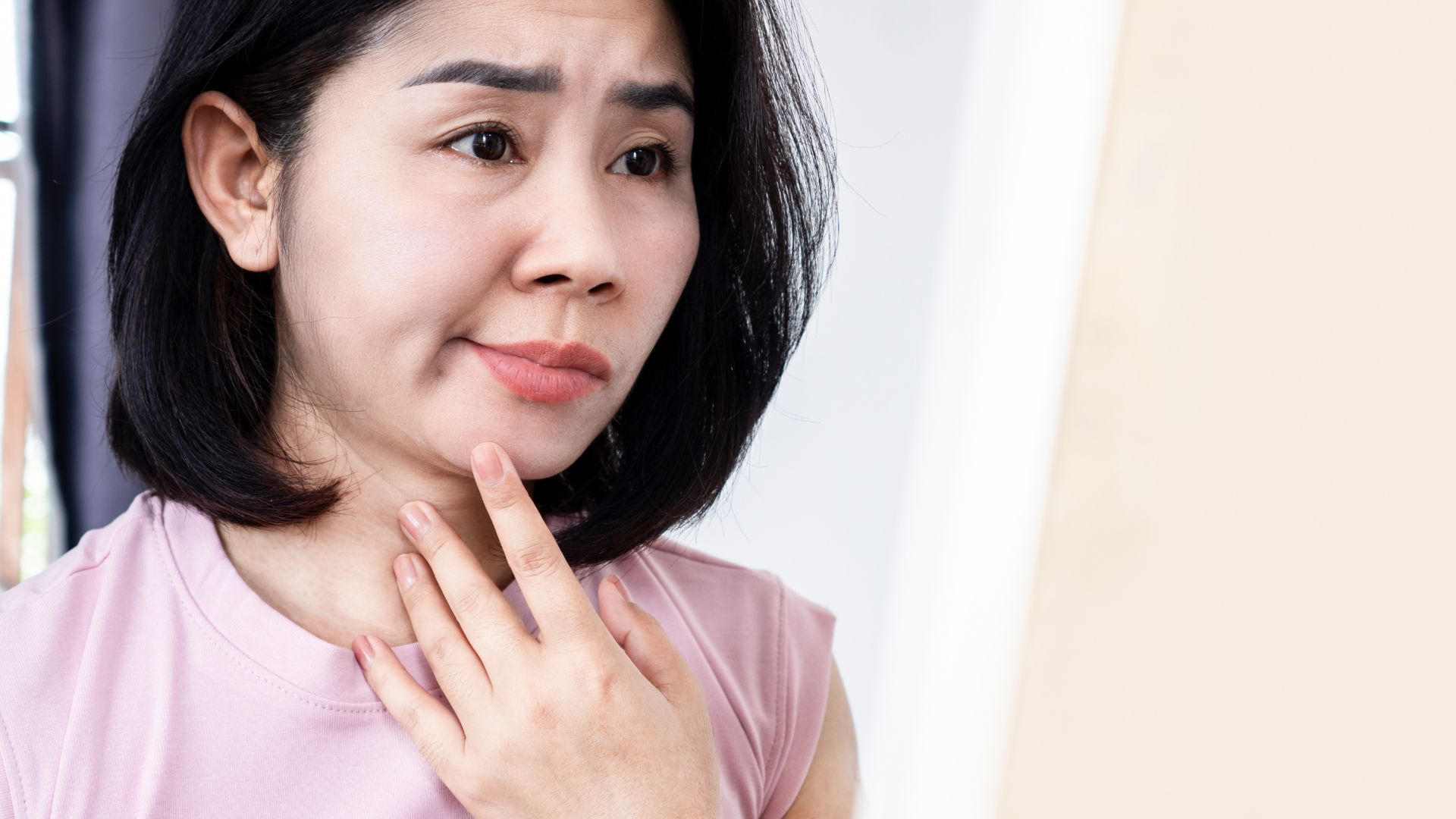 Woman with facial palsy touches face while looking pensive. Facial palsy treatment at Propel Physiotherapy.